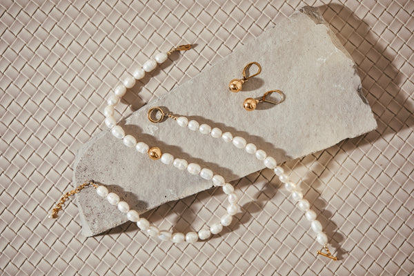 Klas Gold Earrings on concrete slab